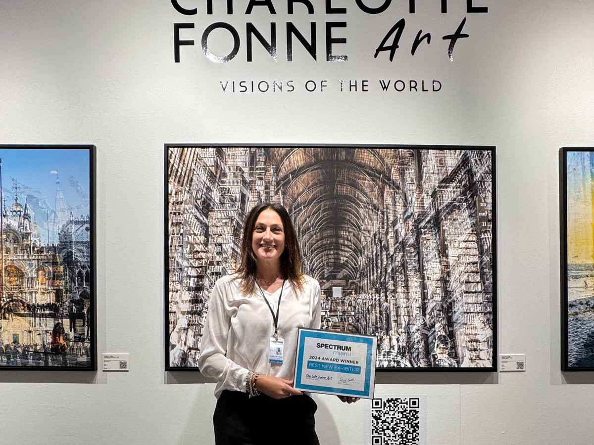Charlotte Fonne holding the Best New Exhibitor award at Spectrum Miami 2024, in front of Trinity Library
