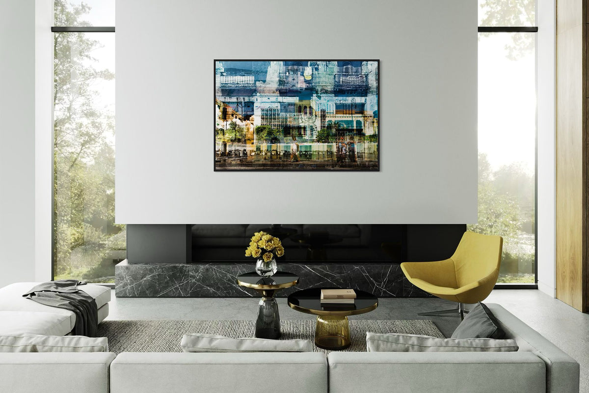 Hermosa Cuba layered photography print in a black floater frame, displayed above a fireplace in a living room with a yellow chair